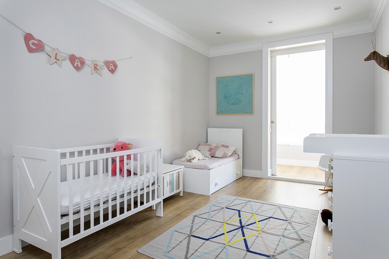 Habitación infantil con una cuna, los muebles para un bebé y decoración infantil muy clara