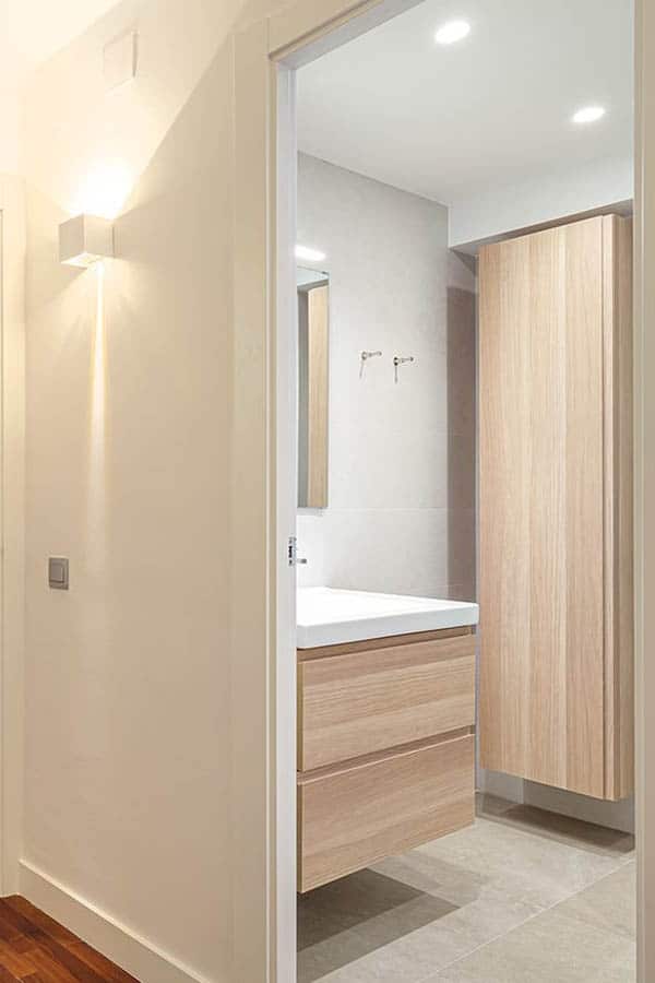 Entrada al baño mediante puertas en tono madera