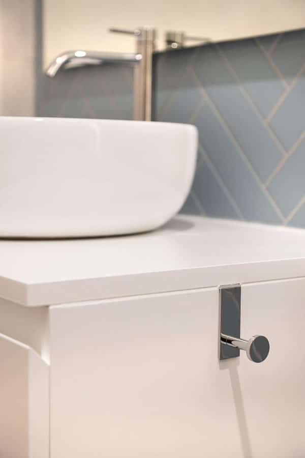 Detalle de lavamanos para baño y colgador metalizado
