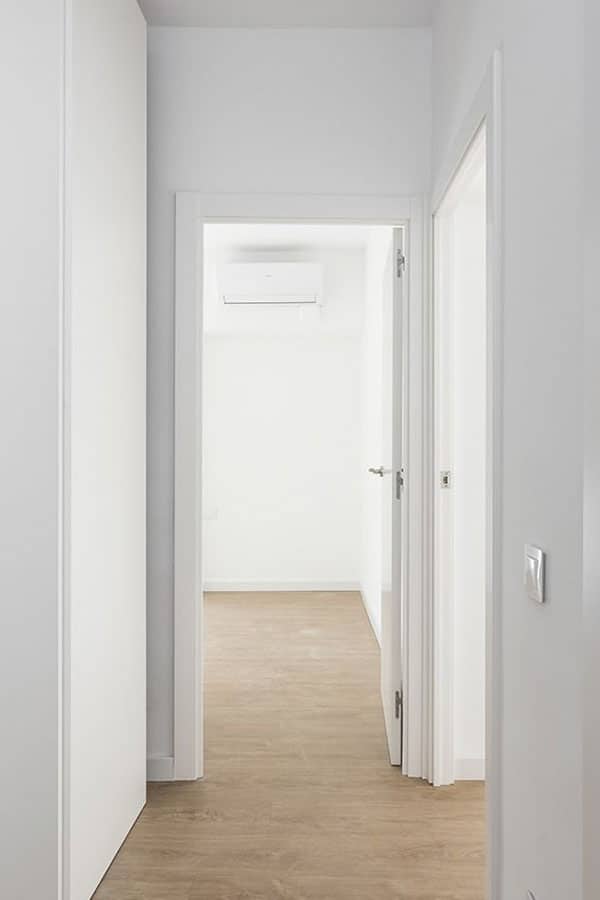 Zona de pasillo con varias puertas en blanco