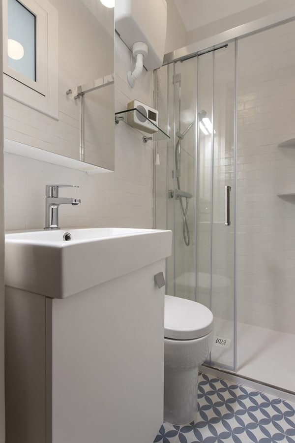 Mueble de almacenamiento en blanco y marrón adaptado a un baño de pequeñas dimensiones