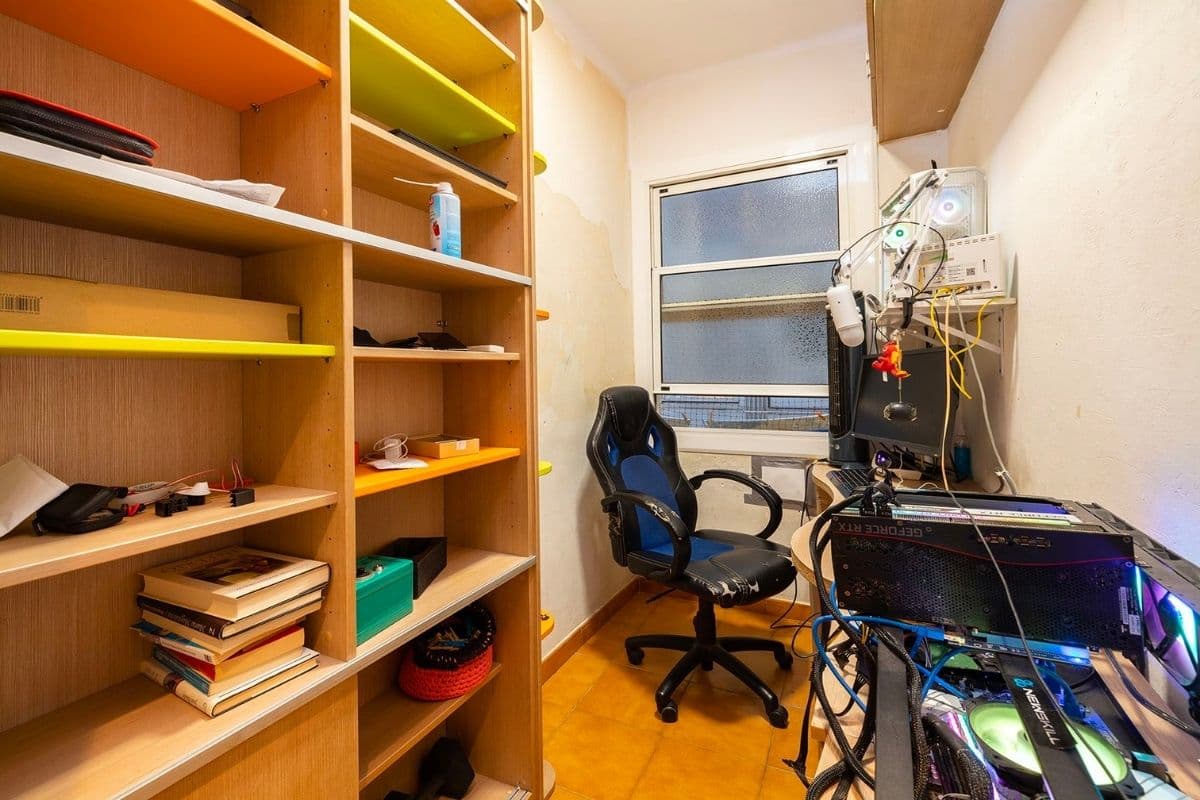 Habitación juvenil con gran estantería y escritorio con ordenador